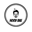 Circle Logo with an image of a black male with a Gotee beard with a pick stuck in his afro with the title Hood Bae underneath him.. 